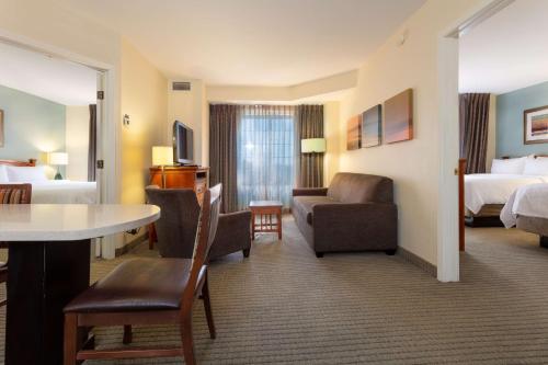 a living room filled with furniture and a large window at Sonesta ES Suites Anaheim Resort Area in Anaheim