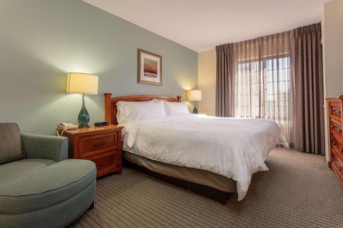 a bedroom with a bed and a chair and a window at Sonesta ES Suites Anaheim Resort Area in Anaheim
