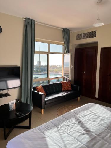 um quarto com uma cama, um sofá e uma janela em بِيُوتات الرفآه - ستوديو بإطلالة بحرية em King Abdullah Economic City
