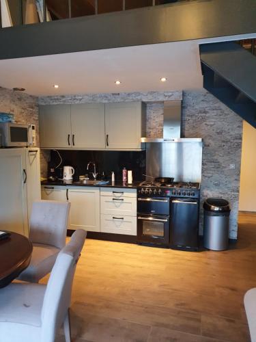 a kitchen with white cabinets and a stove top oven at Tjotter in Amsterdam