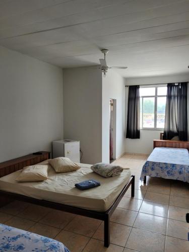 een slaapkamer met 2 bedden en een raam bij Pousada JM in Parque Dom Bosco