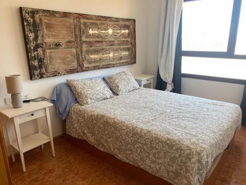 1 dormitorio con cama, mesa y ventana en La Perla de Bahia Sol en Caleta de Fuste