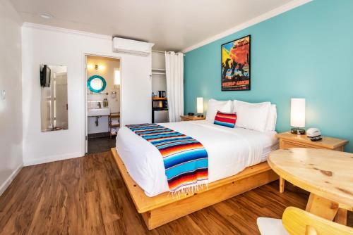 ein Schlafzimmer mit einem großen Bett und einem Tisch in der Unterkunft Agave Inn in Santa Barbara