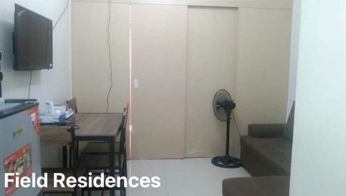 uma sala de estar com um quarto com uma mesa e uma porta em Field Residences em Manila
