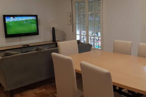 uma sala de estar com uma mesa, um sofá e uma televisão em HERMOSO DEPARTAMENTO EN EDIFICIO MENDOZA CENTRO em Mendoza