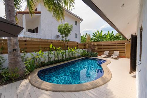 a swimming pool in the middle of a yard at BTC Boutique Resort Private Pool Villas and Studios Hua Hin บ้านทะเลจีน บูติค รีสอร์ท หัวหิน in Hua Hin