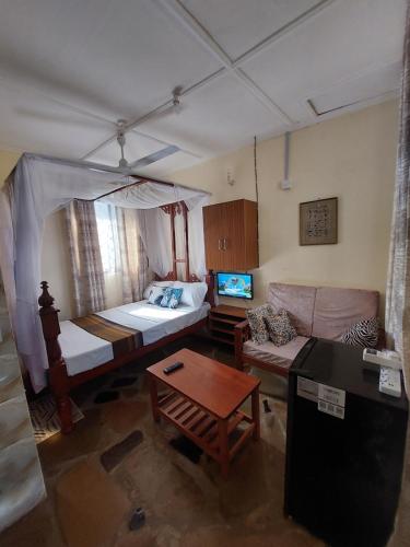 a living room with a bed and a couch at Amarrosi Lion - Studio terrace Apartment ,Mtwapa in Mtwapa
