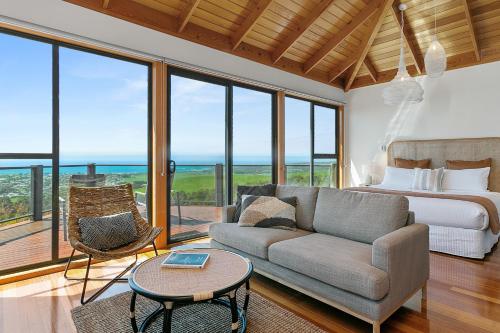 ein Schlafzimmer mit einem Bett, einem Sofa und einem Tisch in der Unterkunft Point of View Villas in Apollo Bay