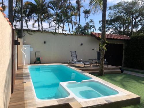 a swimming pool in the backyard of a house at Casa de praia, piscina aquecida, cervejeira e bilhar in Bertioga