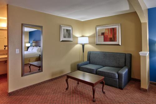 a living room with a couch and a mirror at Holiday Inn Express Hotel & Suites Houston-Downtown Convention Center by IHG in Houston