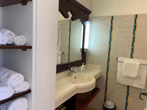 a bathroom with a sink and a mirror and towels at Appartement terrasse vue mer dans village Pierre Vacances in Sainte-Luce