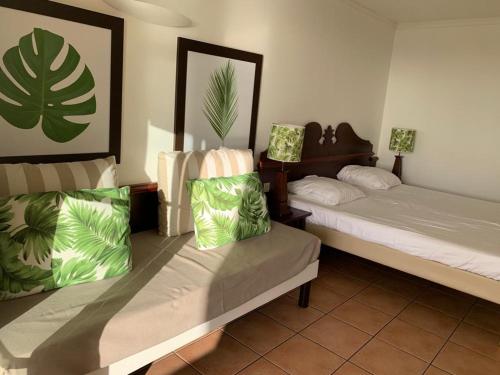 a bedroom with two beds with green pillows on them at Appartement terrasse vue mer dans village Pierre Vacances in Sainte-Luce