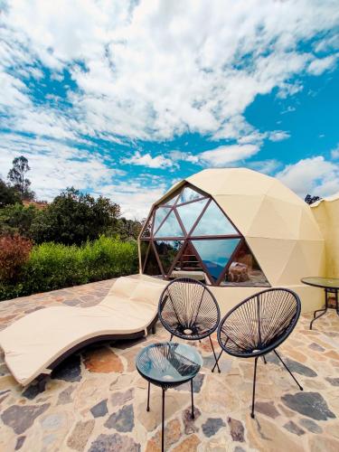 a tent with two tables and two chairs on a patio at Hotel Campestre La Periquera in Villa de Leyva