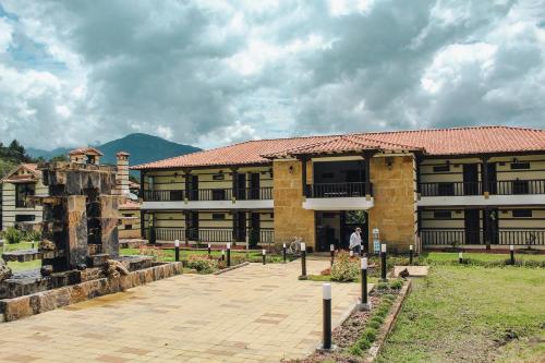 a building with a person standing in front of it at Hotel Campestre La Periquera in Villa de Leyva