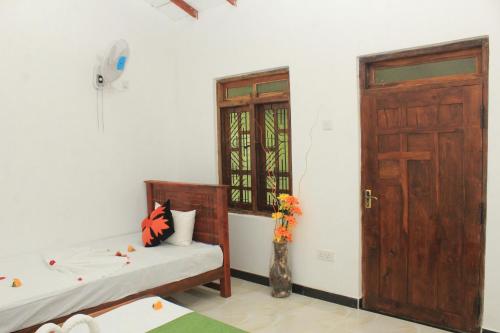 a room with two beds and a door and a window at Sigiriya Hillside View Villa in Sigiriya