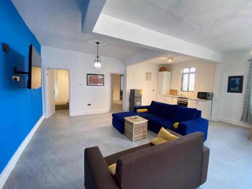 a living room with a blue couch and a kitchen at Legacy Court in Ashalebotwe