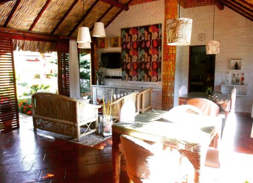 uma sala de estar com mesa e cadeiras e uma cozinha em Pousada Villa Mariposa em Beberibe