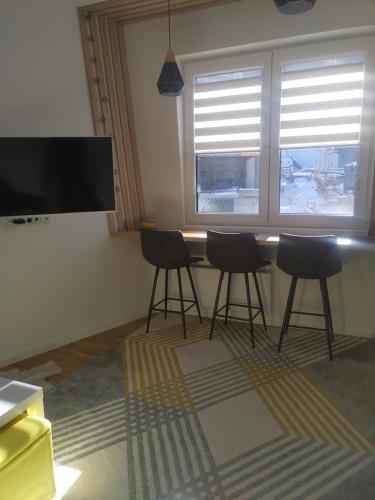 a room with a table with chairs and a large window at Bjelašnica Vukov Vis 09 - apartment with a bedroom in Bjelašnica