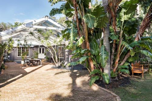 a garden with a greenhouse and palm trees at Yallingup Lodge Spa Retreat in Yallingup
