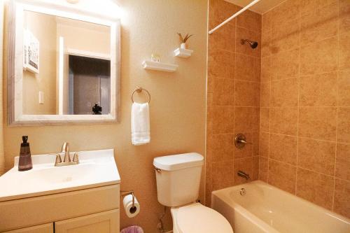 a bathroom with a sink and a toilet and a mirror at Cozy Home - Self Check-In w/Spacious Deck in San Antonio