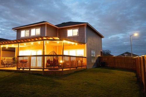 a house with a deck with lights on it at Cozy Home - Self Check-In w/Spacious Deck in San Antonio