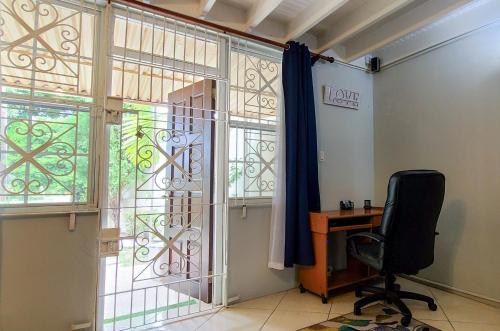 an office with a desk and a chair next to a window at Cheerful 2 - Bedroom Townhouse with free parking in New Kingston in Kingston