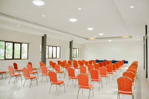 an empty room with orange chairs and tables at Bumi Ciboled Mitra RedDoorz near Gerbang Tol Pamulihan in Jatinangor