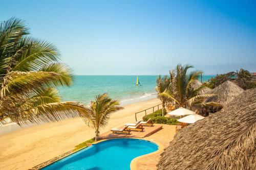 a beach with palm trees and palm trees at Yemaya Boutique Hotel en Canoas in Canoas de Punta Sal