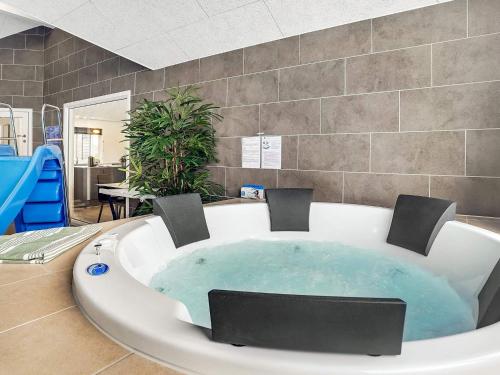 Cette chambre comprend une grande baignoire avec des chaises. dans l'établissement 16 person holiday home in J gerspris, à Jægerspris