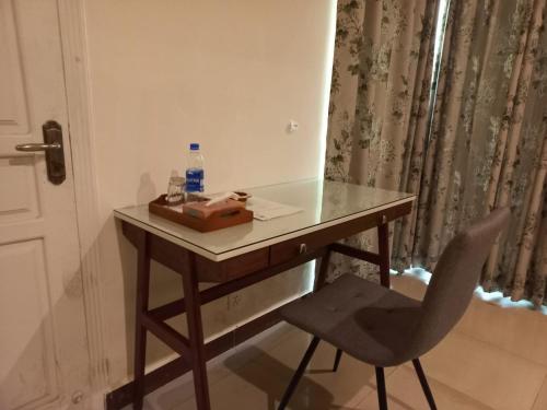 a desk with a bottle of water and a chair at White House Residencia in Rawalpindi