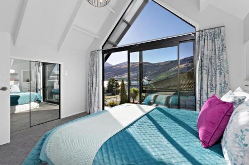 a bedroom with a bed and a large window at The Gables - Queenstown - Beautiful, stylish, newly renovated 4 bedroom home in Queenstown
