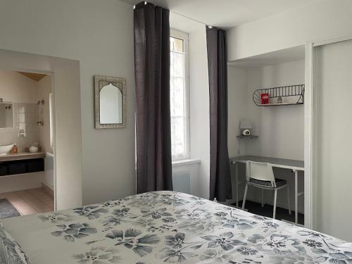 a bedroom with a bed and a desk and a window at Appartement Bar-le-Duc, 2 pièces, 4 personnes - FR-1-585-77 in Bar-le-Duc