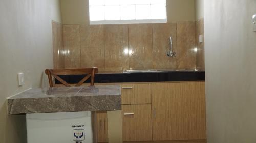 uma cozinha com um balcão, um lavatório e uma janela em Aldeoz Residence Kuta em Kuta