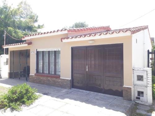 una piccola casa con due serie di porte del garage di Chalet La Mambu a Mar de Ajó