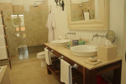 a bathroom with a sink, toilet and mirror at Hotel Casa Quero in Cartagena de Indias