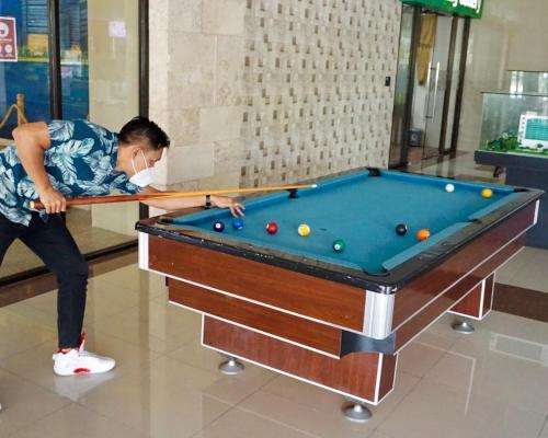 a man is playing a game of billiard at Apartemen MATARAM CITY YUDHISTIRA TOWER YOGYAKARTA in Kejayan