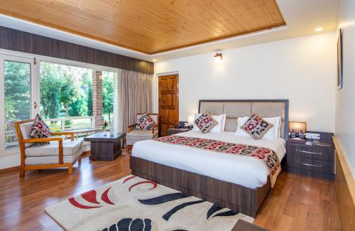 um quarto com uma cama grande e uma janela grande em The Orchard Retreat & Spa em Srinagar