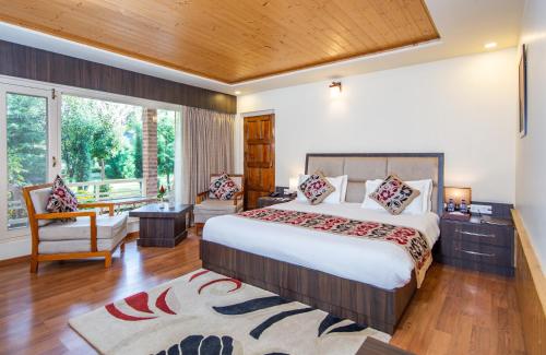 a bedroom with a large bed and a large window at The Orchard Retreat & Spa in Srinagar