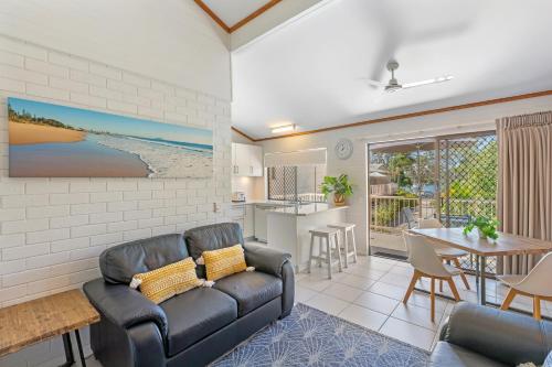 a living room with a couch and a table at Noosa Village River Resort in Noosaville