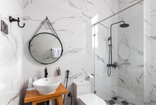 a white bathroom with a sink and a mirror at S Loft Manado in Manado