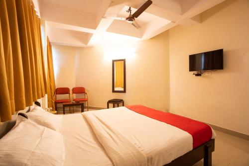 1 dormitorio con 1 cama y TV de pantalla plana en The Sincro Hotel en Madgaon