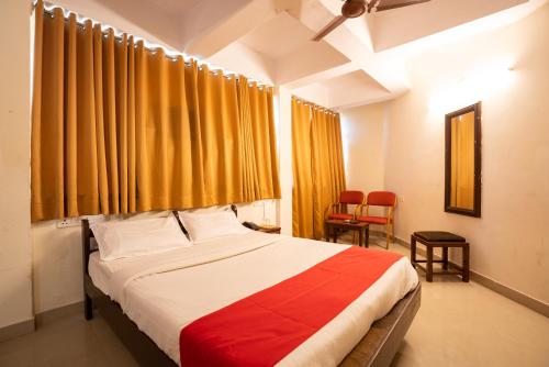 1 dormitorio con 1 cama grande y cortinas amarillas en The Sincro Hotel en Madgaon