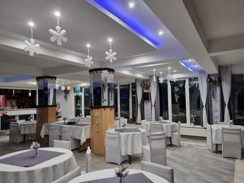 桑丹斯基的住宿－Motel Thessaloniki，一间设有白色桌椅的用餐室