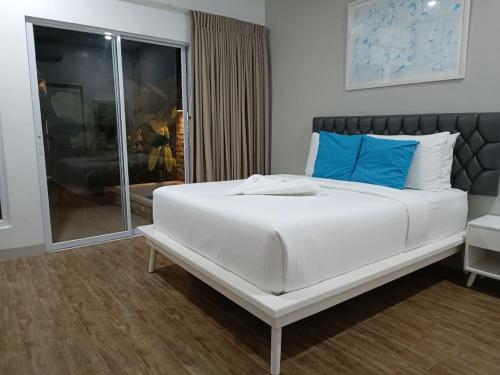 a bedroom with a large white bed with blue pillows at Pineale Villas, Resort and Spa in Panglao