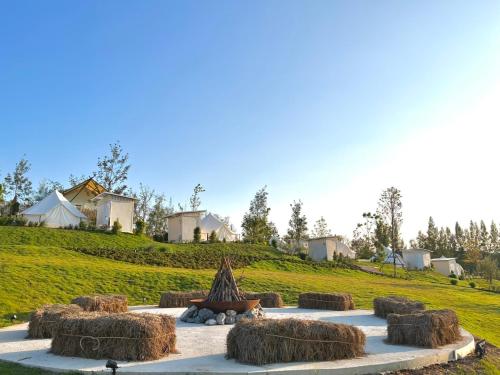 a group of hay bales on a grassy hill at SOL Glamping at Khao yai in Ban Nong Makha