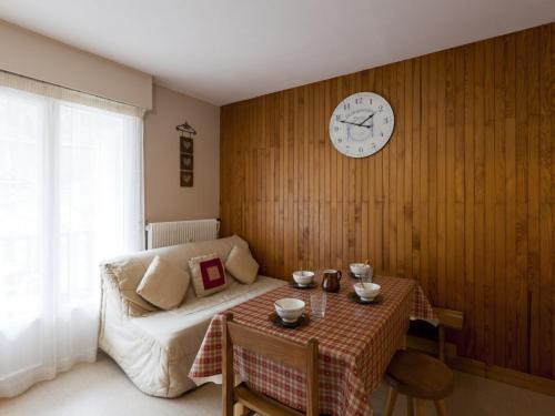 ein Schlafzimmer mit einem Tisch und einer Uhr an der Wand in der Unterkunft Studio Brides-les-Bains, 1 pièce, 5 personnes - FR-1-512-19 in Brides-les-Bains