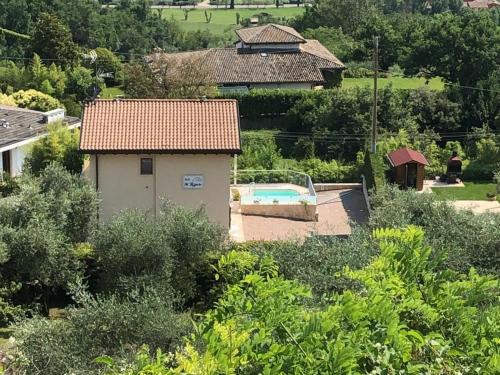 a small house with a swimming pool in a yard at B&B IL RICCIO in Costermano