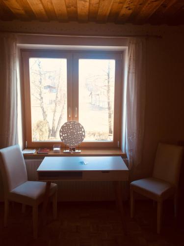 a window in a room with a table and two chairs at Familienapartments mit Balkon oder Terrasse und Garten in Ober-Lembach