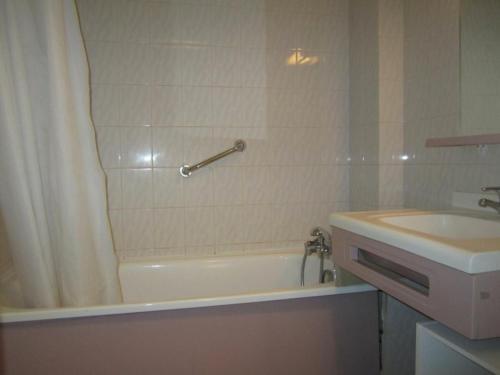 a bathroom with a bath tub and a sink at Studio Brides-les-Bains, 1 pièce, 4 personnes - FR-1-512-231 in Brides-les-Bains