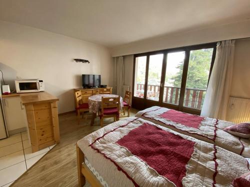 een slaapkamer met een bed en een tafel en een magnetron bij Studio Brides-les-Bains, 1 pièce, 2 personnes - FR-1-512-205 in Brides-les-Bains